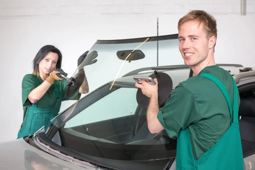 man and woman installing windshield